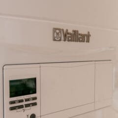 Close-up of a white Vaillant-brand control panel, showing the company logo above a small digital display screen with several buttons below it.
